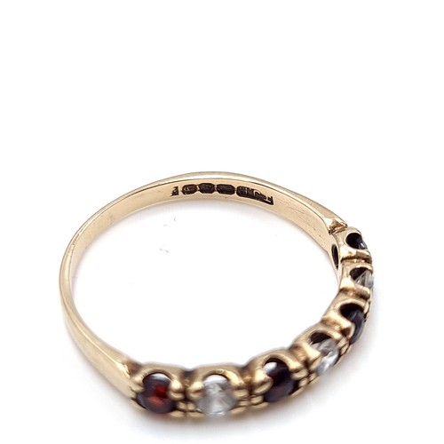 606 - A very pretty garnet and gemstone ring set in nine carat gold. Size P1/2. Weight 1.60 grams. Boxed.