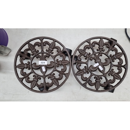 401 - Pair of cast iron trivets featuring a classical fleur-de-lis design.