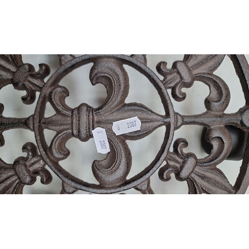 401 - Pair of cast iron trivets featuring a classical fleur-de-lis design.