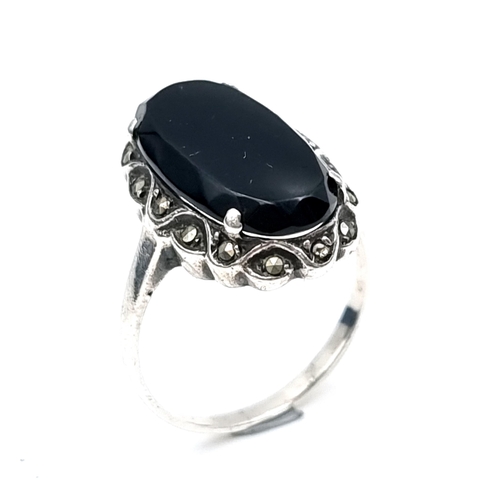 55 - A nice example of an oval onyx stone ring with marcasite mount set in sterling silver. Ring size - R... 