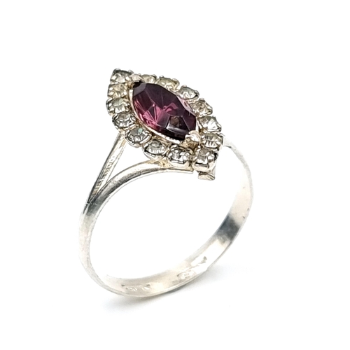 57 - A sterling silver dark amethyst ring set with gemstone surround. Ring size - Q. Weight - 2.27 grams.... 