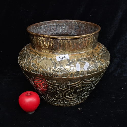 134 - An antique large brass planter featuring intricate hand-embossed motifs of fawns amidst lush foliage... 