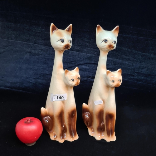 140 - A charming tall pair of two tone ceramic cat figures.