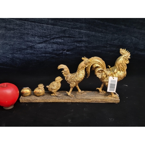 149 - A charming figure of a family of chickens painted in a gilt gold finish and mounted on a wooden base... 