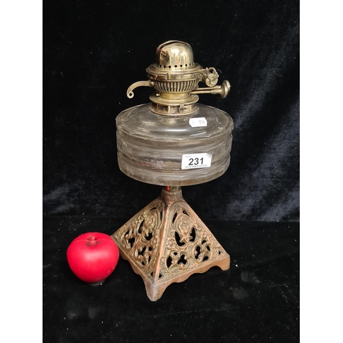 231 - A wonderful Victorian oil lamp with cast iron base and glass oil reservoir. Polished brass to top.