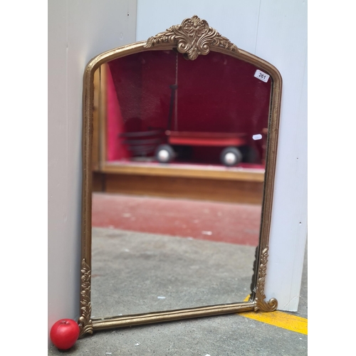 261 - An elegant gilt wall hanging mirror. Housed in an ornate gilt frame. 63cm w 80cm