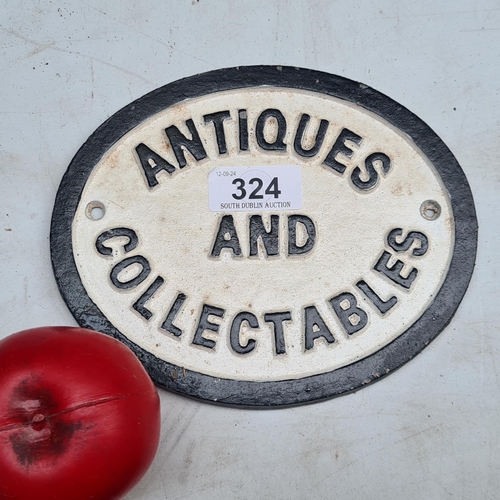 324 - A cast metal advertising wall sign featuring 'Antiques and Collectibles'.