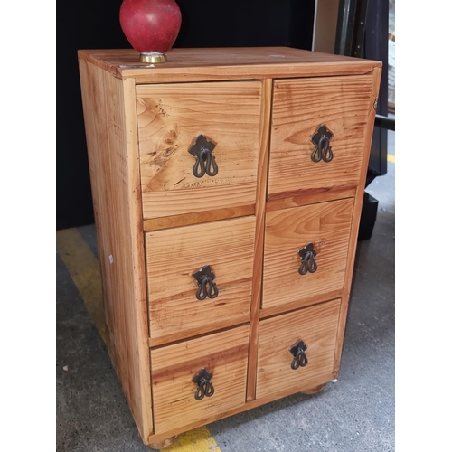 384 - A rustic solid pine storage chest featuring six neatly sized drawers and metal hardware.