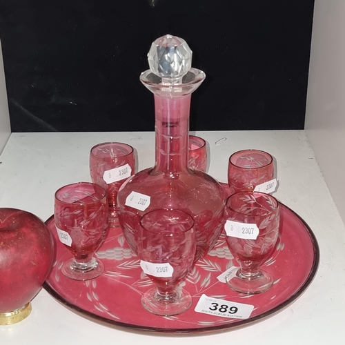 389 - A beautiful vintage cranberry glass drinks decanter set comprising of a decanter, tray and six glass... 