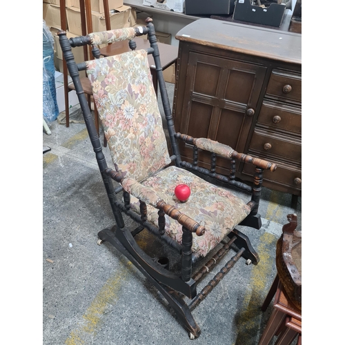 645 - A wonderful Victorian high back rocking chair upholstered in floral tapestry fabric. Held on ceramic... 