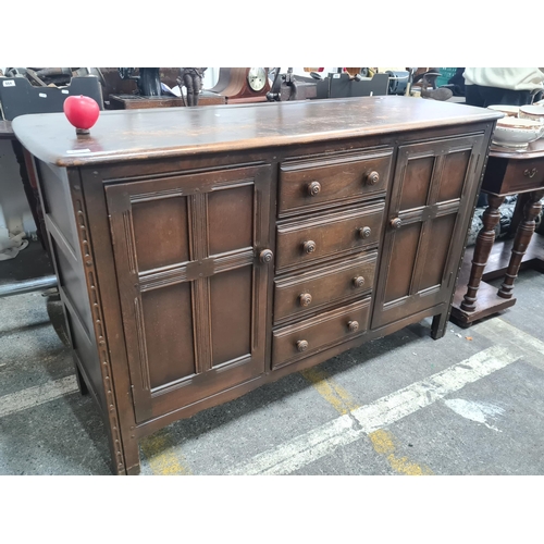 655 - Star Lot : An Ercol Old Colonial dark elm vintage sideboard / dresser. Boasts carved detailing to ed... 