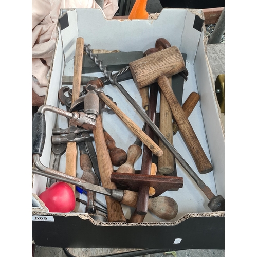 669 - A large box comprising of tools including hammers of various size, wooden hammer, chisels, sharpenin... 