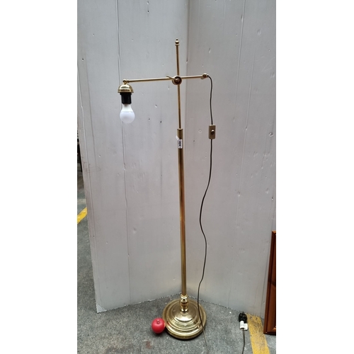 424 - Brass adjustable floor lamp with a single bulb holder and corded switch. It has a simple and elegant... 