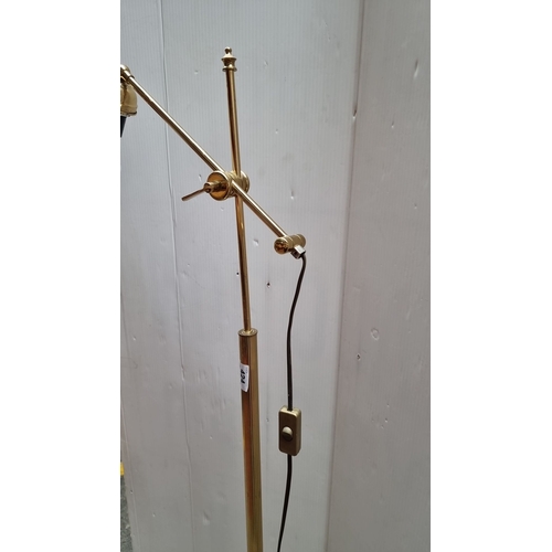 424 - Brass adjustable floor lamp with a single bulb holder and corded switch. It has a simple and elegant... 