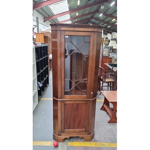 428 - Star Lot : A Mahogany corner cabinet with glazed door and geometric muntins, featuring upper and low... 