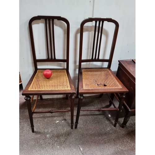 431 - Pair of Victorian mahogany chairs with spindle backs and caned seats, featuring turned legs and cros... 