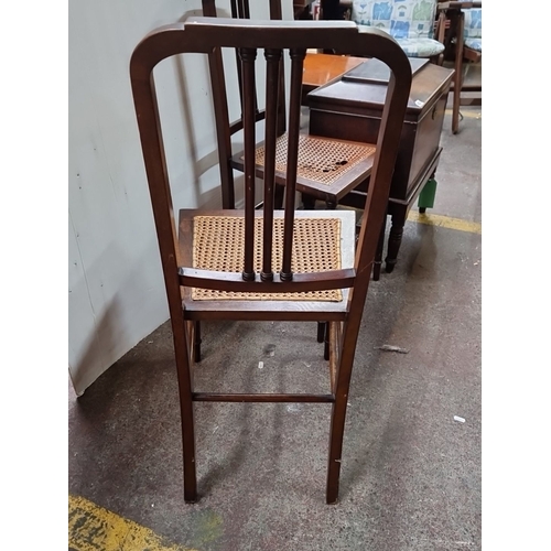 431 - Pair of Victorian mahogany chairs with spindle backs and caned seats, featuring turned legs and cros... 