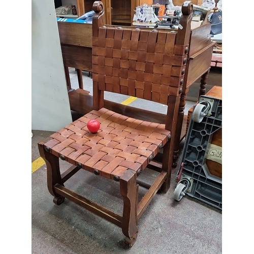 438 - Woven leather strap oak chair, featuring hand-tooled detailing. Oversized example.