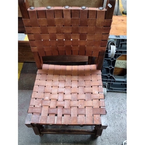 438 - Woven leather strap oak chair, featuring hand-tooled detailing. Oversized example.