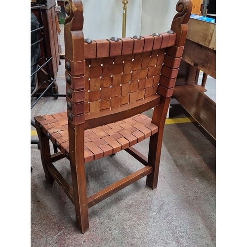 438 - Woven leather strap oak chair, featuring hand-tooled detailing. Oversized example.