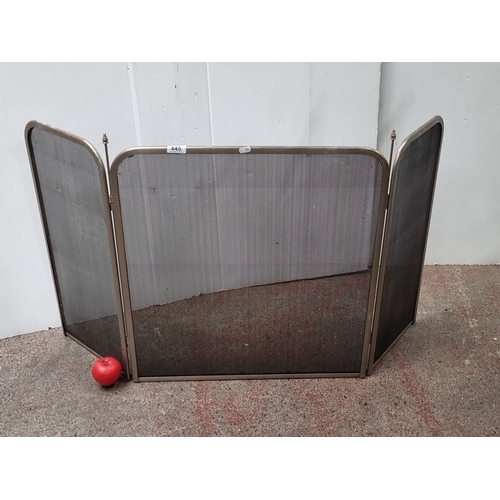 445 - Three-panel metal mesh fireguard with folding sides and decorative finials.