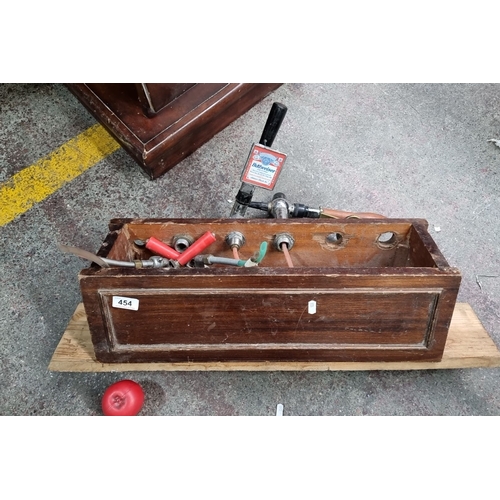 454 - Vintage draught beer tap system features a wooden box enclosure with multiple tap connections, inclu... 