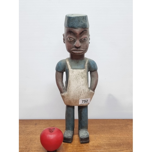 752 - A characterful hand carved wooden African figure of a young working male.