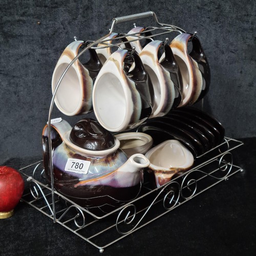 780 - A 15 piece pottery tea set including tea pot, cups and saucers. Comes with wire rack for organizatio... 