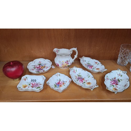 809 - Seven Royal Crown Derby pieces including six pin dishes and a milk jug. All featuring the 