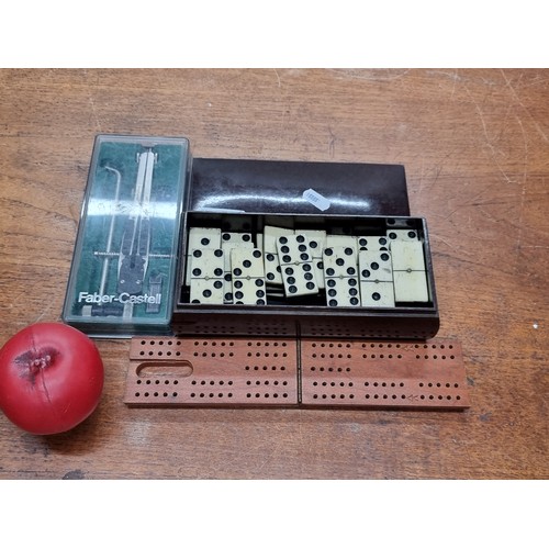 756 - Three items including a dominos set housed in a Bakelite box along with a cribbage board and a Faber... 