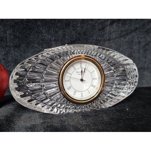 825 - Waterford Crystal clock, cut glass design with Roman numeral dial, gold-tone accents. Oval shape.