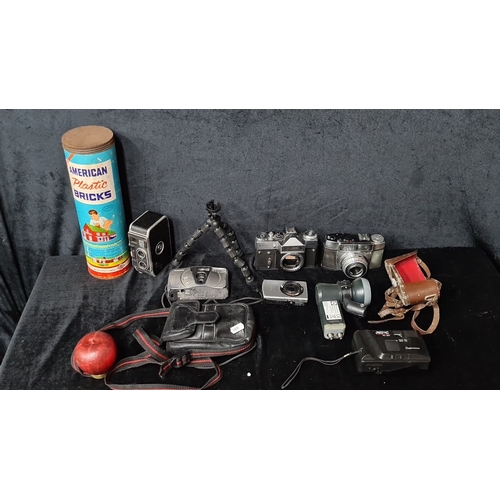 828 - Mixed lot of vintage cameras including a bolex , Zenit, Kodak, Canon, and Praktica, flexible tripod,... 