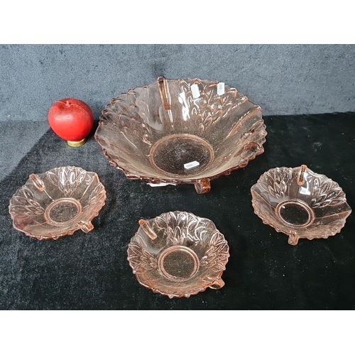 829 - Set of four pink depression glass bowls featuring intricate floral designs, includes one large bowl ... 