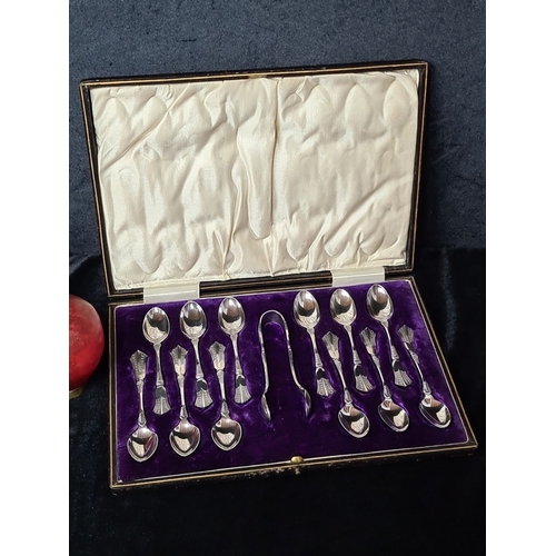 831 - Set of 12 Silver plated teaspoons in a fitted case with matching tongs. The case has a velvet interi... 