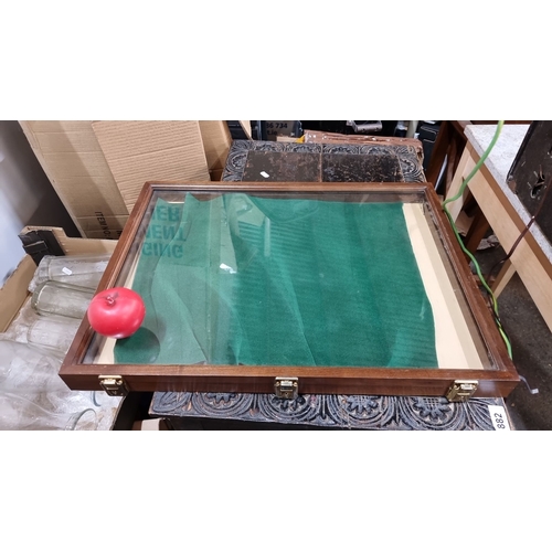 886 - Wooden display case features a glass top, green felt interior, and dual brass latches.