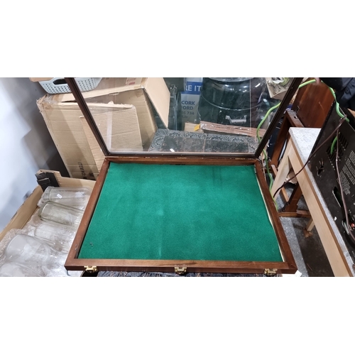 886 - Wooden display case features a glass top, green felt interior, and dual brass latches.