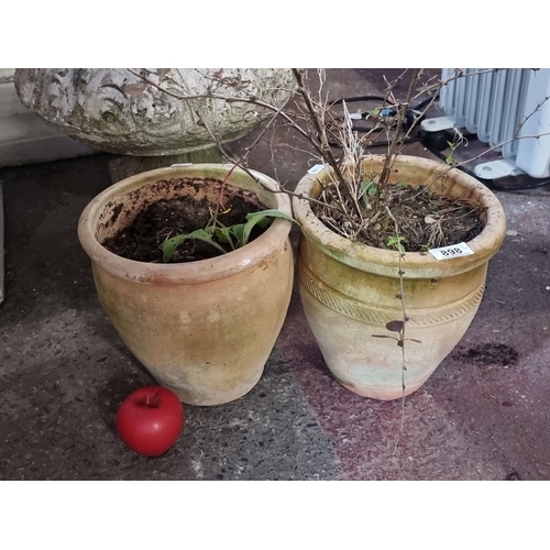 898 - Pair of terracotta garden pots with plant remnants. Simple decorative bands accentuate the natural e... 