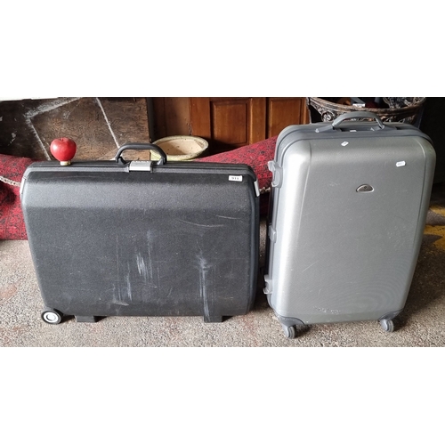 911 - Set of two Samsonite hard shell suitcases, featuring a combination lock and rolling design.