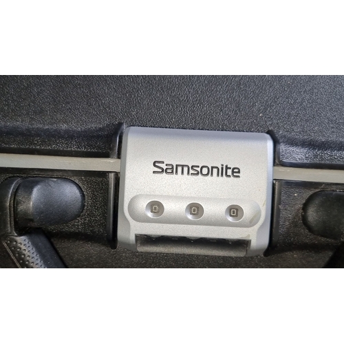 911 - Set of two Samsonite hard shell suitcases, featuring a combination lock and rolling design.