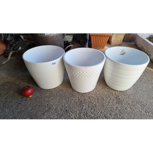 919 - Set of three white plastic planters, featuring various textures and designs, including geometric and... 