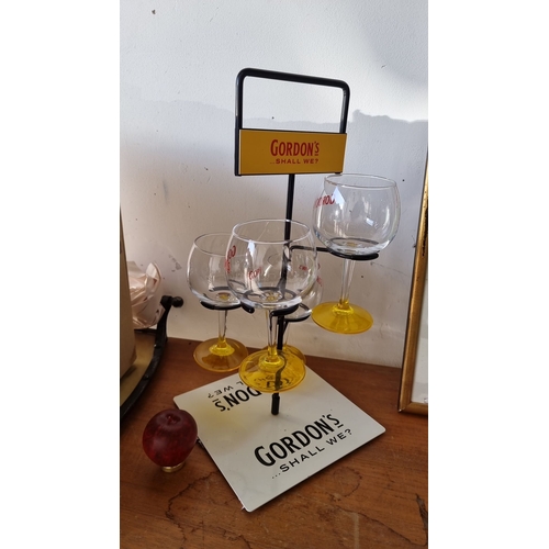 928 - Gordon's gin promotional rack with four branded glasses, featuring yellow stems and 'Shall we?' slog... 