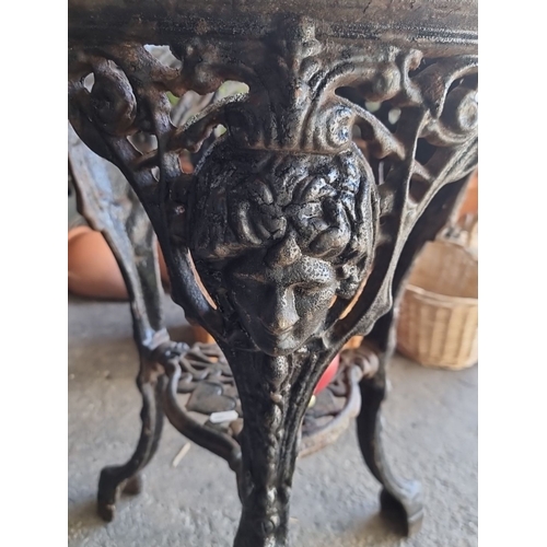 936 - Victorian cast iron stand featuring intricate floral and face motifs.