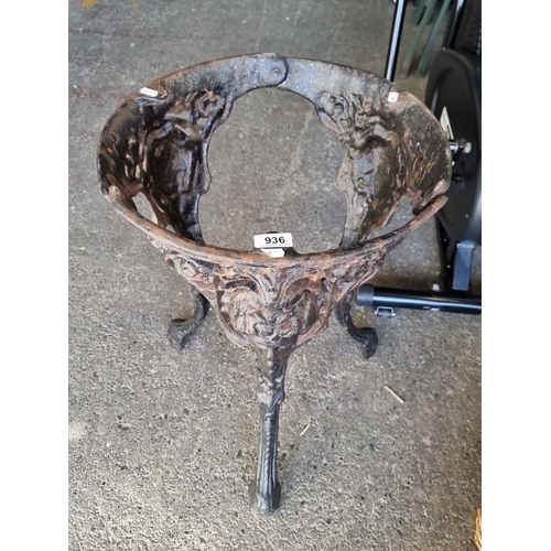 936 - Victorian cast iron stand featuring intricate floral and face motifs.