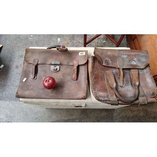 957 - Pair of vintage leather satchels, featuring robust worn leather, with buckle and clasp closures.