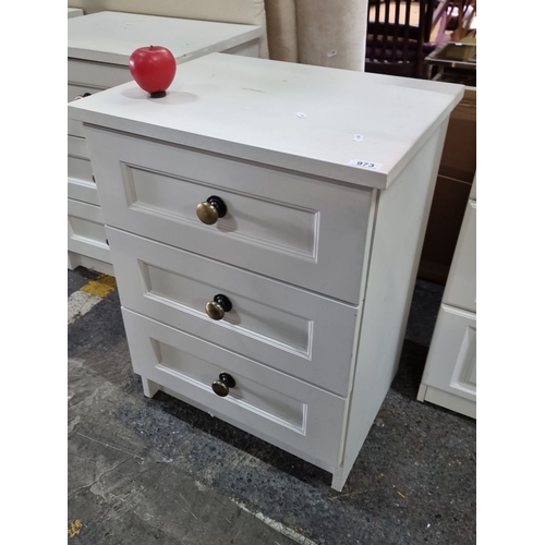 973 - White three-drawer wooden dresser with mixed metal knobs. It's a watch to the next pair if you need ... 