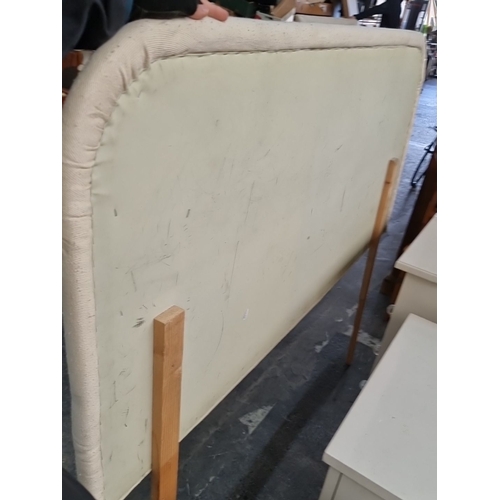 976 - Rectangular upholstered headboard in off-white fabric, supported by two wooden legs. 
MM: 150 x 73 c... 