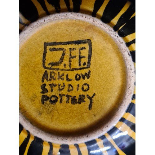 115 - Three pieces of the iconic John Ffrench Arklow Studio pottery including a cup and two side plates in... 