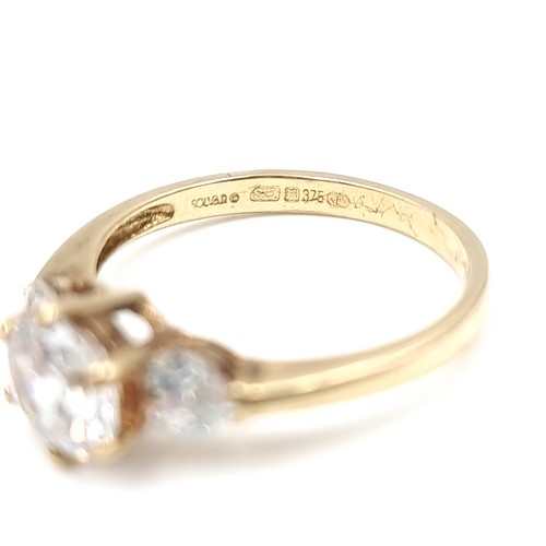 578 - A nine carat gold three stone cubic Zirconia stone ring. Ring size - O. Weight - 2.45 grams. Boxed.