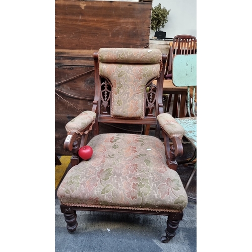 434 - Victorian upholstered armchair features an intricately carved mahogany frame and floral tapestry fab... 