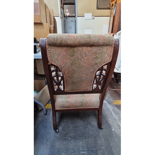 434 - Victorian upholstered armchair features an intricately carved mahogany frame and floral tapestry fab... 